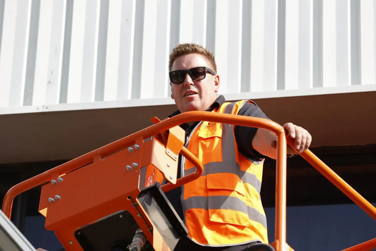A Cornerstone Pest Control technician in hi-vis and safety glasses working from a powered access platform